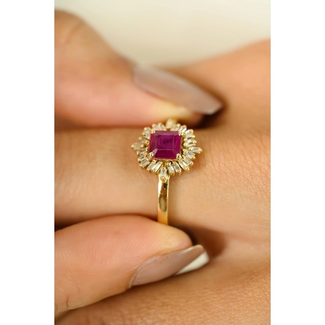 Exude timeless charm with this exquisite ruby and diamond halo ring, crafted in radiant 14K yellow gold. At the center...