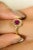 Exude timeless charm with this exquisite ruby and diamond halo ring, crafted in radiant 14K yellow gold. At the center...