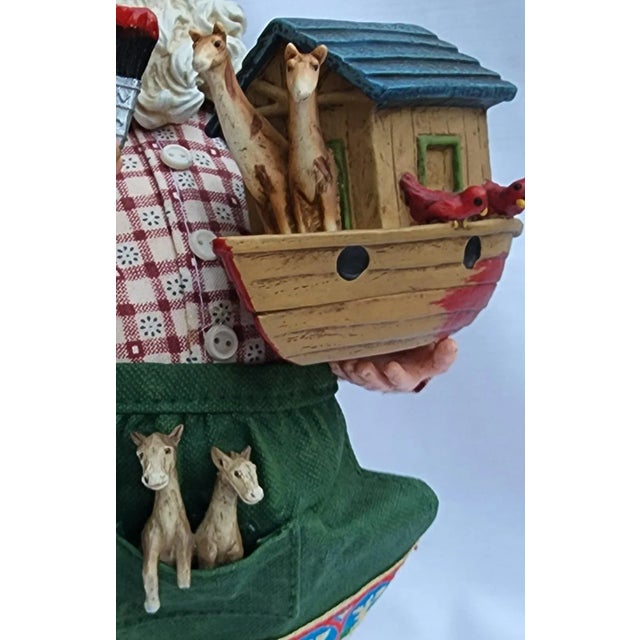 This vintage fabric mâché Santa is busy finishing up a toy Noah's ark, complete with lots of animals. In his carpenter...