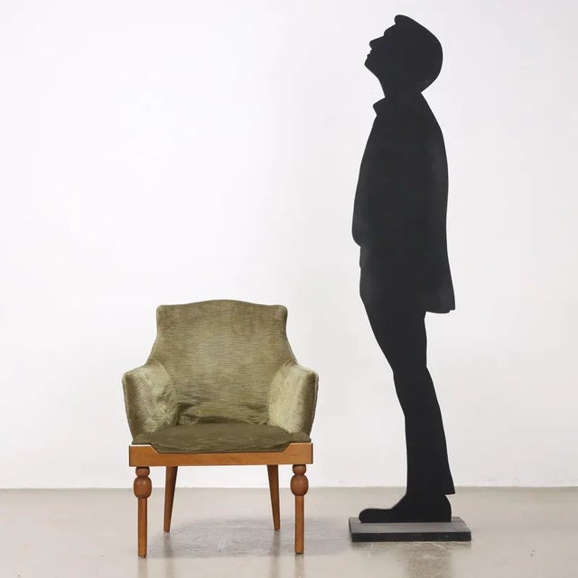 Armchair with foam padding, velvet covering and wooden base. This piece is attributed to the mentioned designer/maker. It...