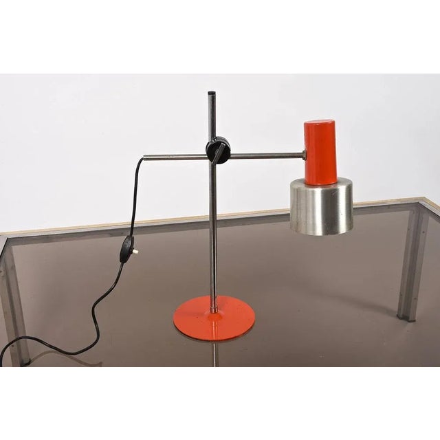Amazing mid-century orange metal and aluminum adjustable table lamp. This wonderful item was produced in italy during the...