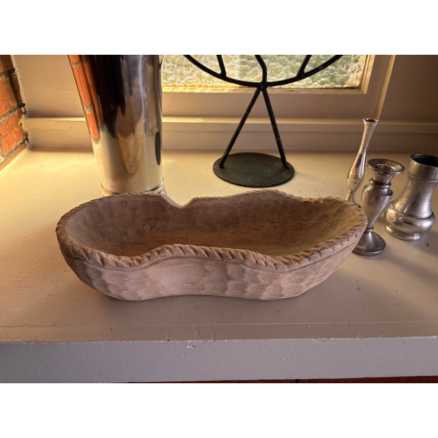 Rustic vintage hand-carved wood dough bowl featuring an elongated organic form and distinctive scalloped, hand-notched...