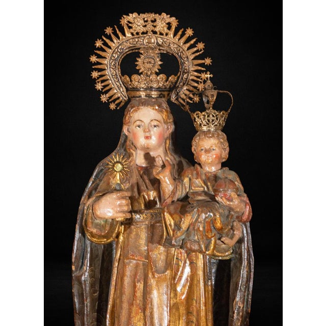 A finely carved Spanish Virgin and Child sculpture dating to the early 16th century, executed in polychromed and gilded...