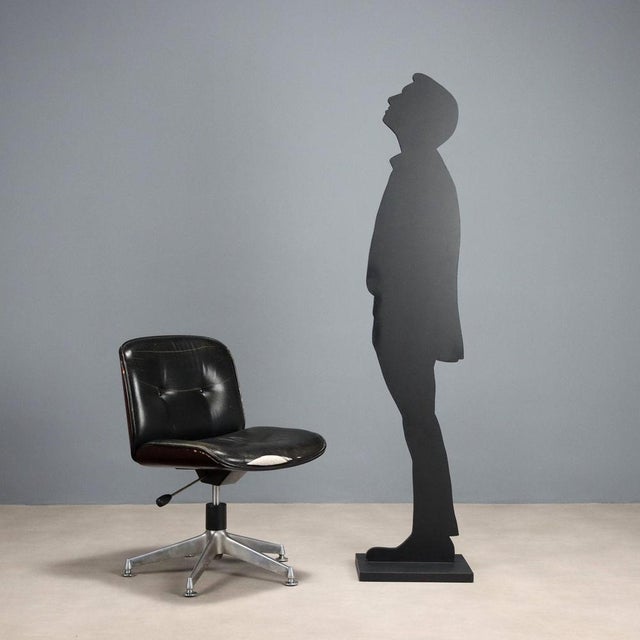 Armchair with metal legs, black leather seat to be redone and curved wood shell. This piece is attributed to the mentioned...