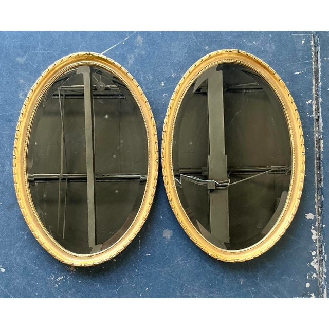 This exquisite pair of vintage Hollywood Regency oval mirrors is a masterful example of Neoclassical-inspired design. Each...
