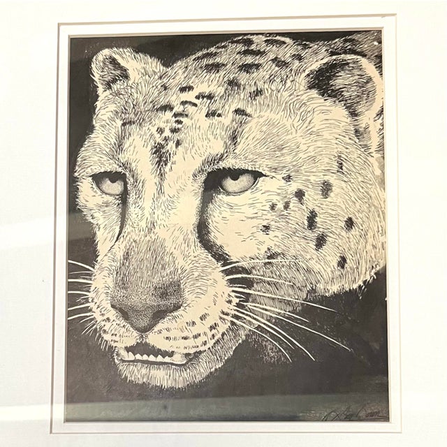 This artwork is a framed, black-and-white wildlife original ink drawing depicting a leopard's face. Artist signed on the...