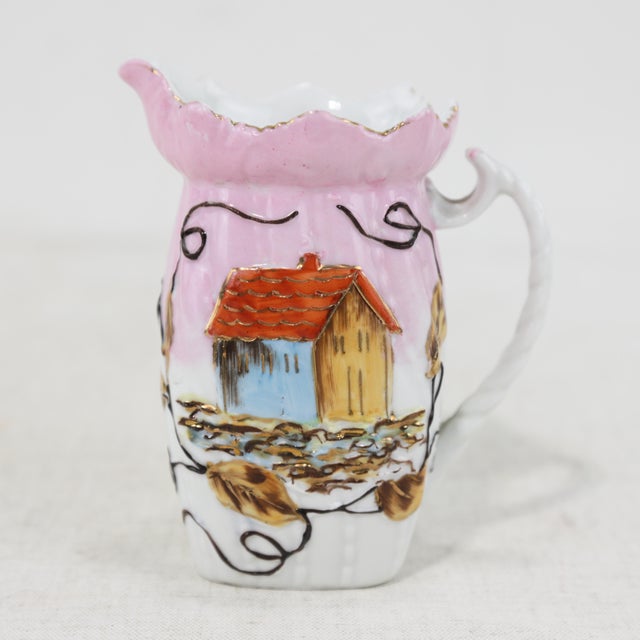 This charming set includes two intricately decorated Victorian-era porcelain mugs and a matching small pitcher, each...