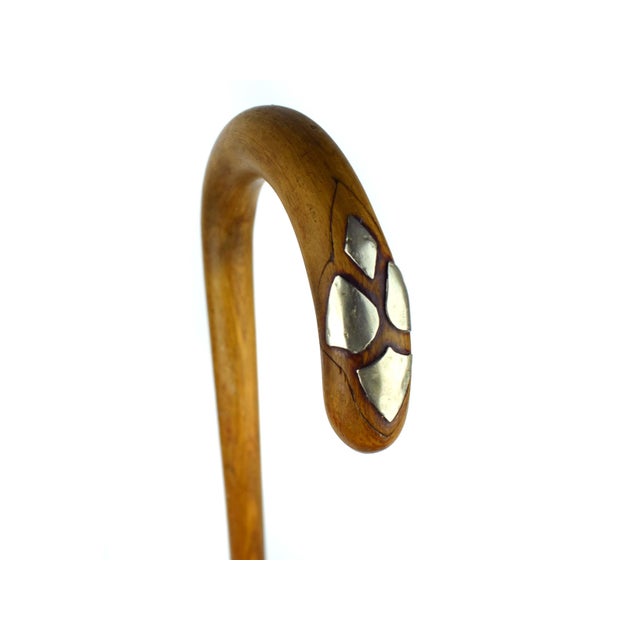 This elegant antique walking cane is a testament to understated craftsmanship, blending organic form with refined detail....