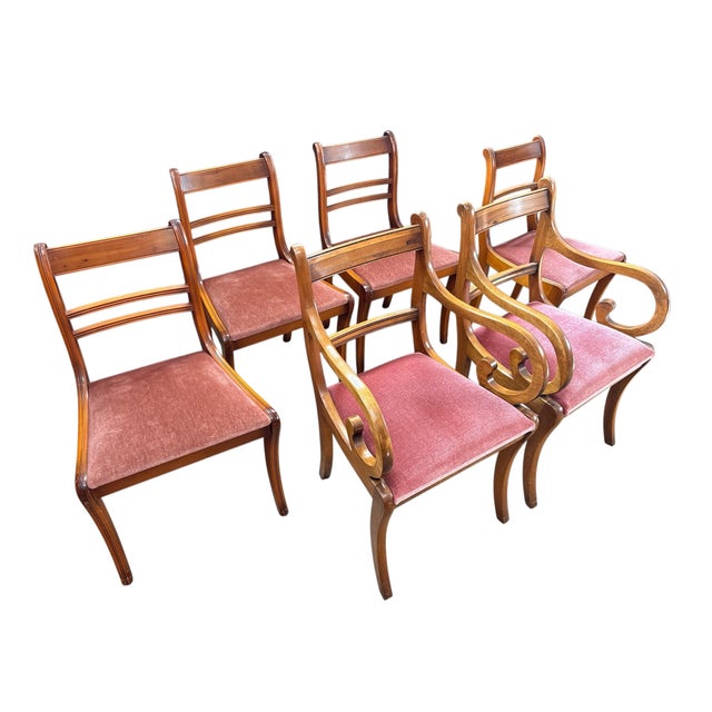 Set of six classic wooden dining chairs in the Regency style. The set includes two armchairs and four regular chairs. They...