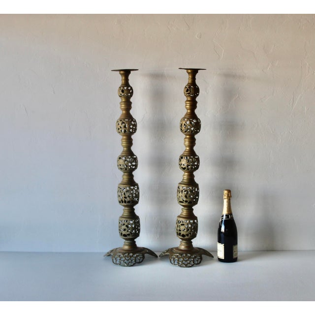 Vintage Mid Century Altar Size Pierced Brass Floor Candlestick Holders Ornate Reticulated Design. The candlesticks feature...