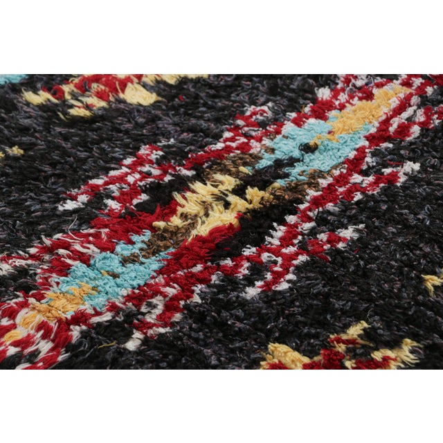 Hand-knotted in wool and originating from Morocco circa 1950-1960, this 2x9 vintage runner rug is a rare and among the...