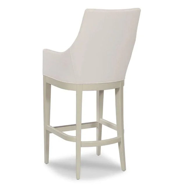 A curved oval upholstered back resides above an upholstered seat elevated on graceful tapering legs.