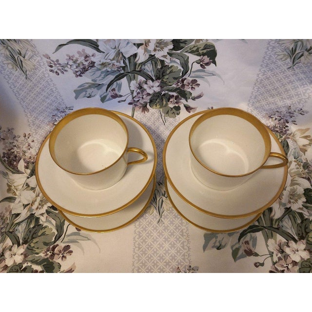 Set of four large chocolate or tea cups decorated with a large golden net. Early 20th century.