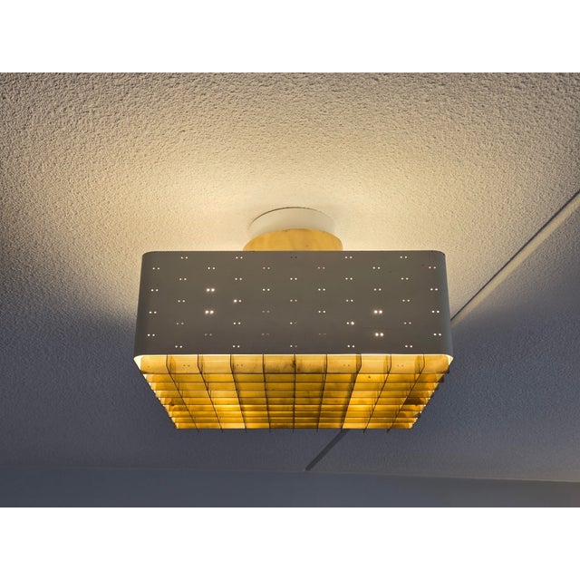 Paavo Tynell's "Starry sky" ceiling lamp, model 9068, brass and white painted metal, glass plate on top of the grille. The...