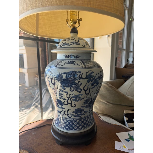 A timeless blue and white porcelain table lamp in the classic ginger jar form, featuring intricate figural and cloud...