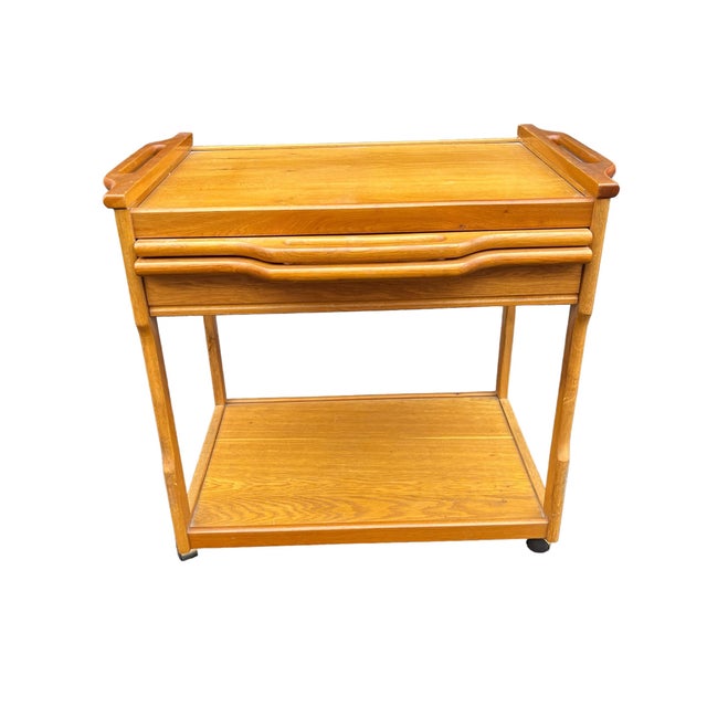 Beautiful serving cart on wheels. wood graining looks like oak or teak. white pull out tray 28 x 21.5, flat part on top is...