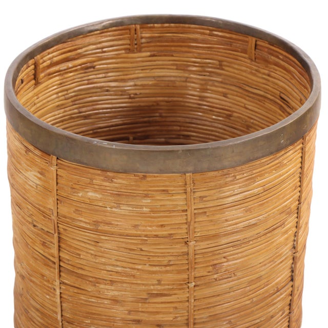 Combining natural woven rattan with polished brass accents in a refined mid-century design, this cylindrical form features...