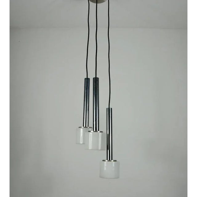 This striking cascade pendant lamp from the 1970s embodies the clean lines and refined elegance of mid-century modern...