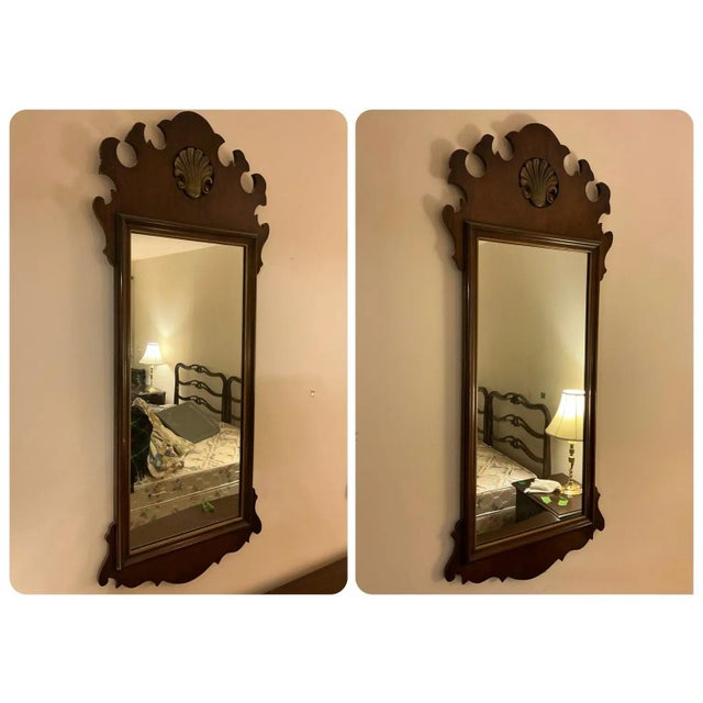 A pair of tall Chippendale-style mirrors in mahogany with scrolled crests, carved shell cartouches and shaped bottom...