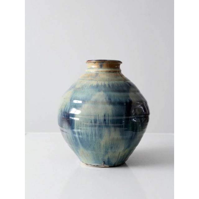 This is a vintage studio pottery vase. Signed by the artist, the large, dynamic vase has a subtle ridged design with...
