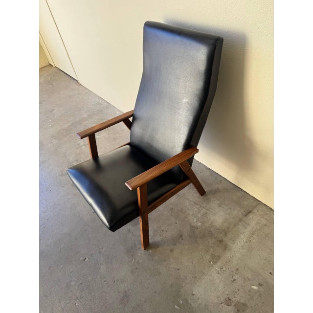 Scandinavian high-back lounge chair from the 1960s, crafted with a solid teak frame and sleek sculptural lines. The...
