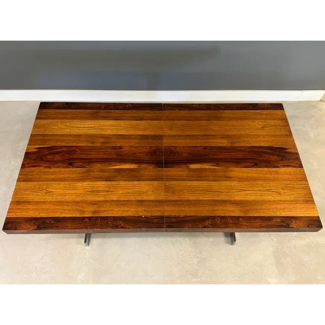 A mid century modern rosewood, ash and walnut top dining table with chrome base in the style of Milo Baughman....