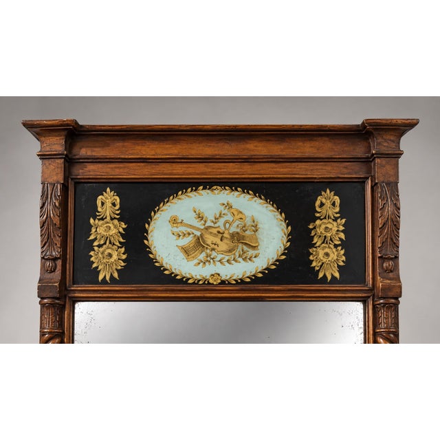 A tall wooden pier mirror featuring twist-turned side columns and a classical architectural cornice at the top. The upper...