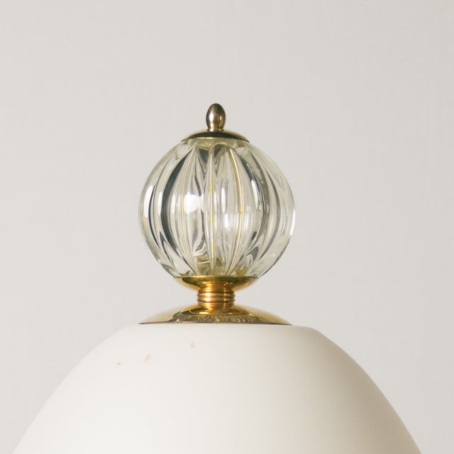 This table lamp is made of white glass with a satin finish. Its organic shape, with an oval design, lends an elegant and...