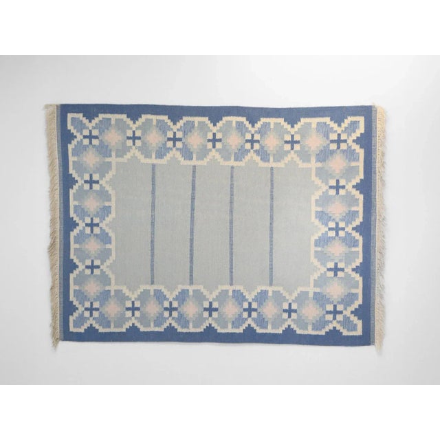 A large example of a mid-century Swedish kilim in tones of blues and cream. Geometric border design with dark blue edging....
