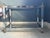 Neoclassical chrome, brass & glass low rectangular table. The glass plate held by a cage form base with X supports, brass...