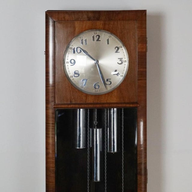 An Art Deco burr and figured walnut Longcase Clock. Eight day movement with quarter hour Westminster chimes. Dimensions: H...