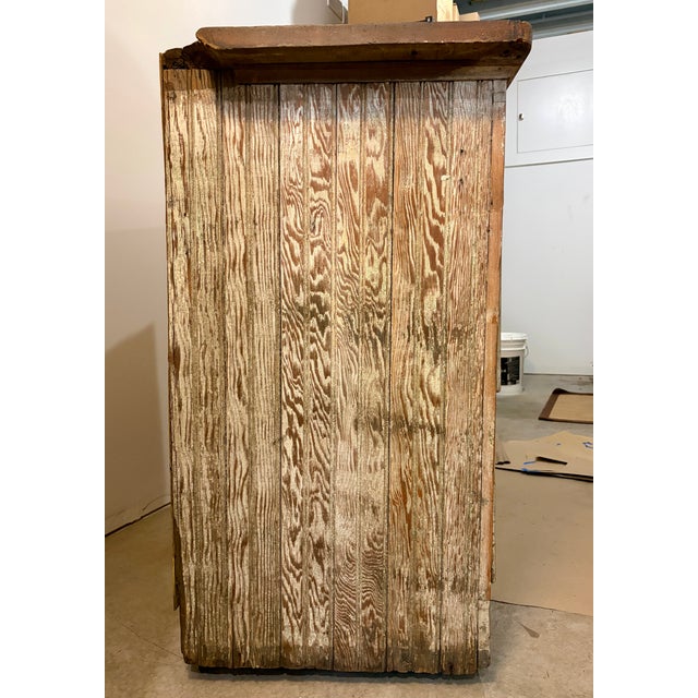 This antique primitive cabinet exudes rustic charm with a weathered paint finish and original hardware. An early 20th...