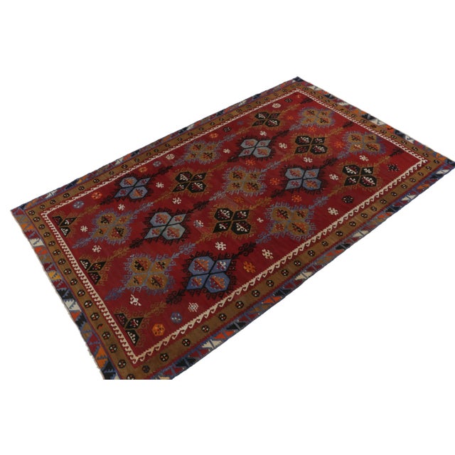 A vintage 7x12 Kilim rug, handwoven in wool originating from Turkey circa 1950-1960. Enjoying a play of tribal motifs and...