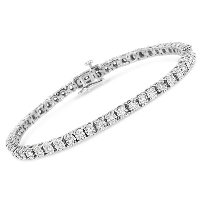 Elegant and timeless, this gorgeous pure 92.5% sterling silver tennis bracelet features 1 carat total weight of round lab-...