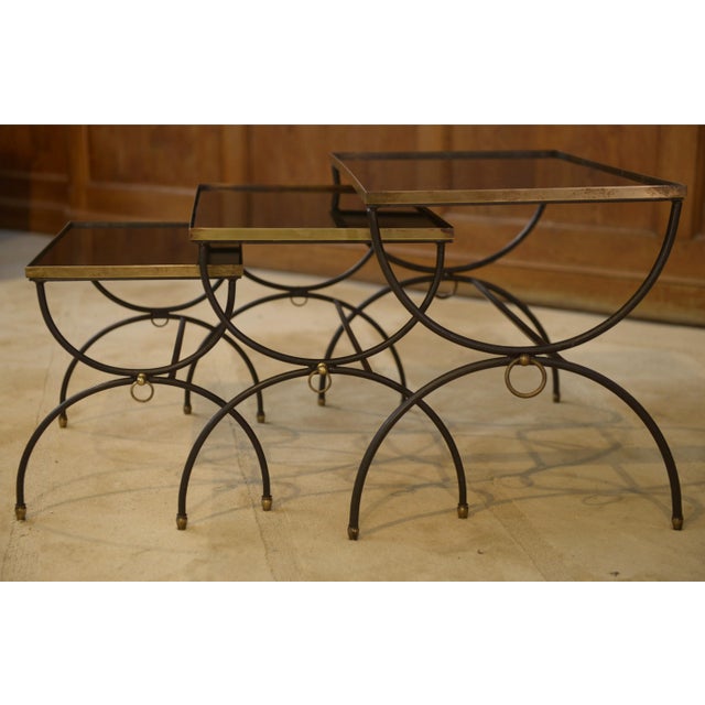 Signs of wear on the glass. A rare set of three nesting tables with a very elegant design, in the style of Jean Royère....