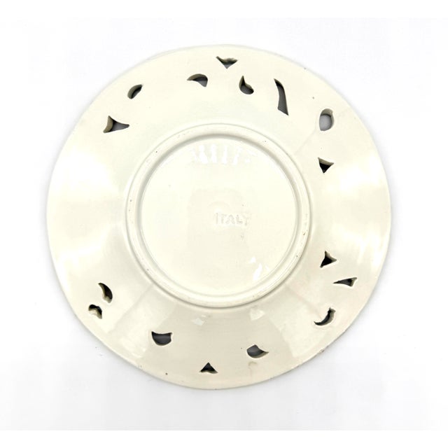 This beautiful 8" reticulated plate is one of five in our collection, each with a unique floral majolica painting with...