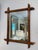 This is a French antique faux-bamboo wall mirror with a hand-carved wood frame. The frame is wood that has been shaped and...