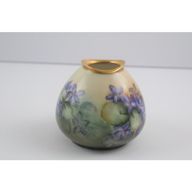 A charming hand-painted German porcelain bud vase decorated with delicate violet blossoms against a softly blended ground....