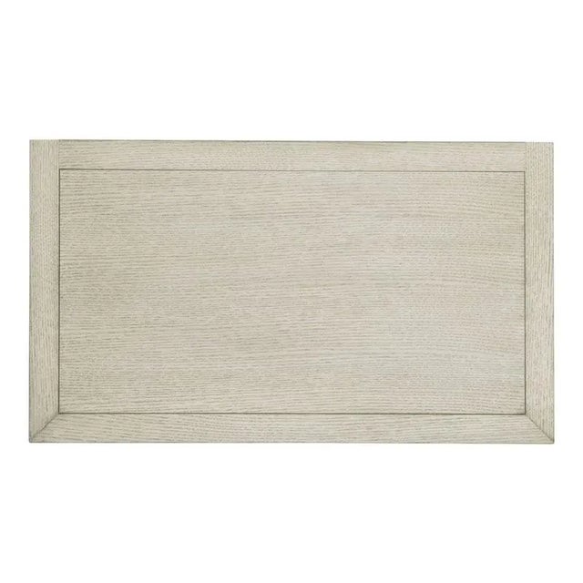 A rectangular top over squared corner posts that flank an open storage area and a low drawer overlaid with woven raffia...