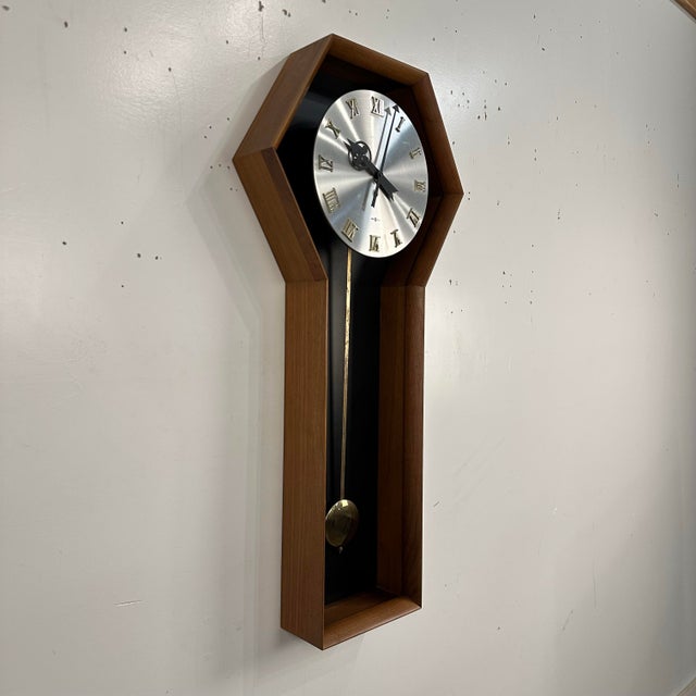 This is a rare Arthur Umanoff for Howard Miller #557 Coffin pendulum wall clock. It features a beautiful walnut frame with...