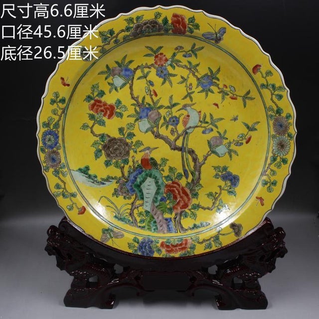 This impressive large porcelain charger features a vibrant yellow ground adorned with elaborate famille rose enamel...