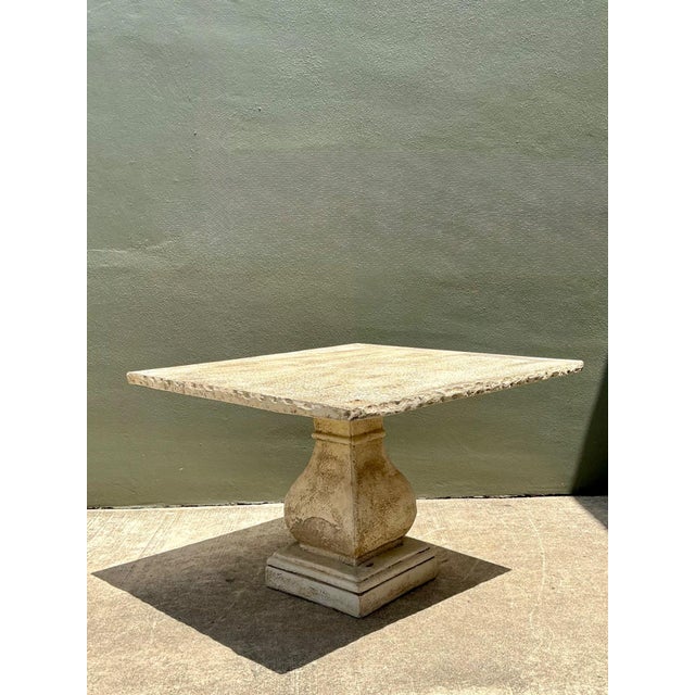 This vintage square dining table is a masterwork of architectural permanence, skillfully cast in heavy-duty cement to...