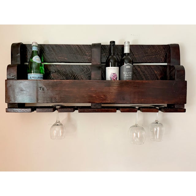 Handmade rustic oak wall-mounted wine holder rack in a high-gloss dark walnut stain. Has grooves for hanging six wine...