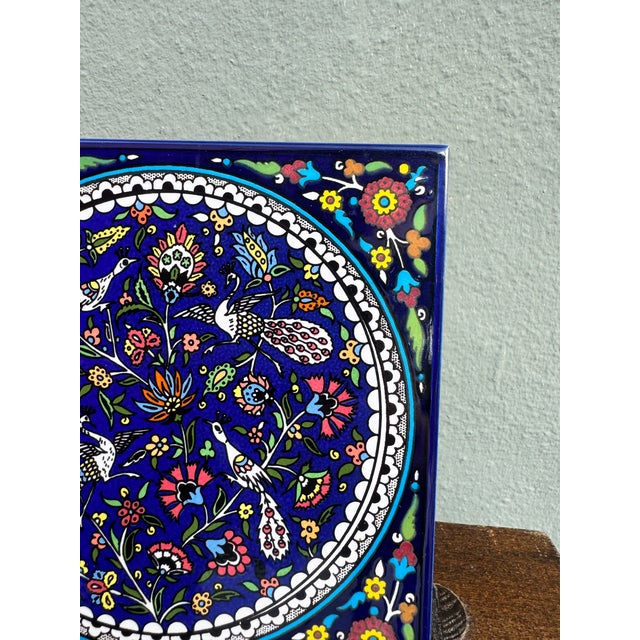 A magnificent hand-painted decorative ceramic wall tile on a deep cobalt blue ground, featuring an intricate central...