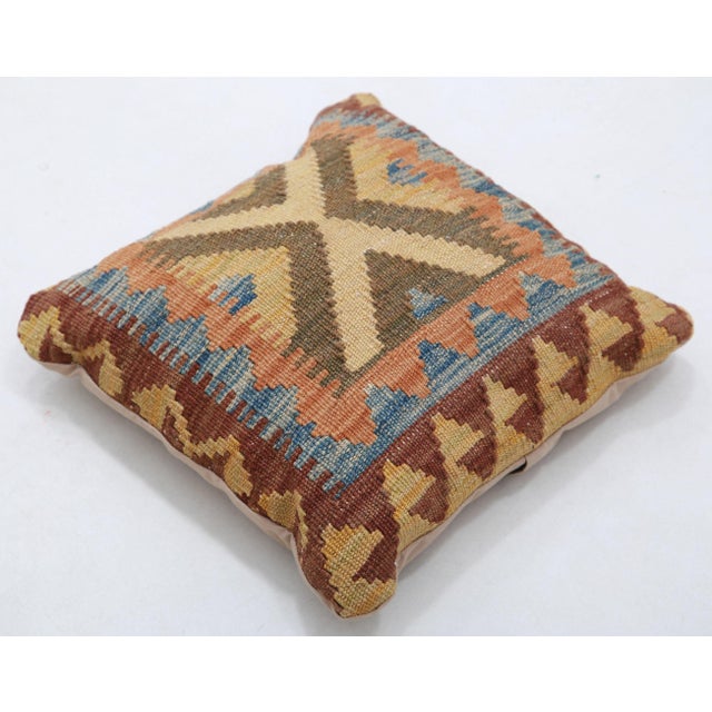 A one-of-a-kind handwoven Afghan wool kilim accent pillow featuring central cross medallion with a terracotta border. Cut...