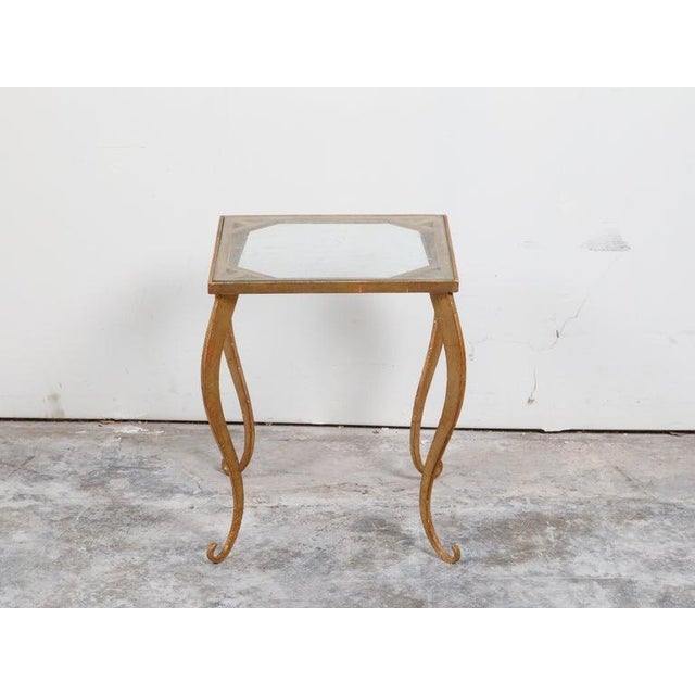 A vintage French gilt metal side table from the mid-20th century, with glass top and cabriole legs. Created in France...