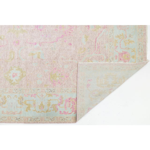 Hand-knotted from 100% wool, this modern Oushak-style rug features a refined medallion design with delicate floral motifs...