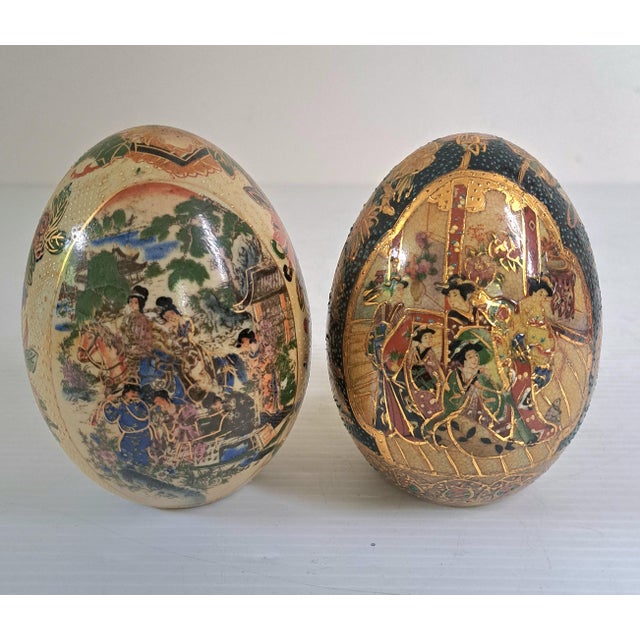 A beautiful vintage pair of Satsuma‑style porcelain decorative eggs, each hand‑painted with colorful figural scenes,...