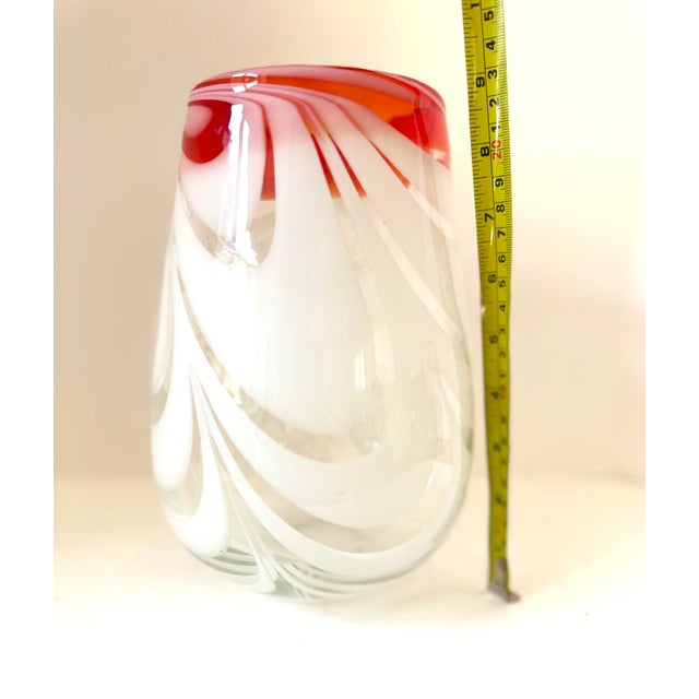 A striking vintage art glass vase featuring flowing white ribbon-like swirls suspended within clear glass and finished...