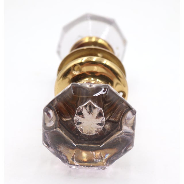 Vintage passage door knob set with octagon glass knobs and new brass rosettes. The glass has a faint gray tint. The...